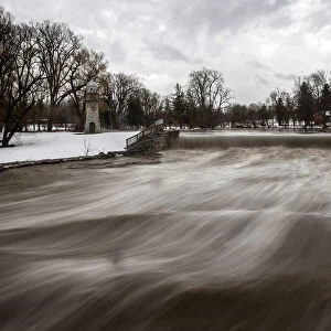 Cayuga Creek water rushes past a neighbourhood following a massive snow storm in