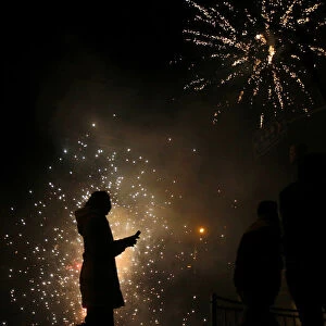 A girls walks as residents set off fireworks as part of Chinese New Year celebrations