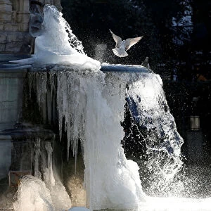 Ice partially covers a fountain on a cold winter day in central Brussels