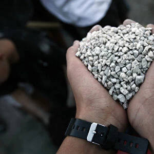 Israeli boy holds a fist full of gravel as he takes part in a building activity at the