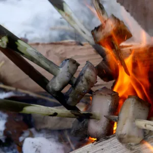 Local residents put pig fat in a camp fire during the celebrations of Kolyada pagan