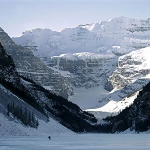 A lone hockey player skates on frozen Lake Louise in Canadas Banff National Park