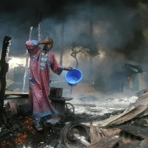 A man rinses soot from his face, Lagos 2006