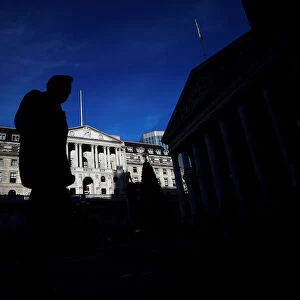 A man is silhouetted as he walks past the Bank of England in the City of London