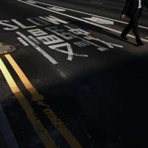 A man walks past a sign on a road blocked by pro-democracy protesters at the financial
