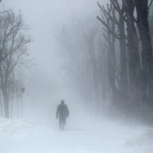 A man walks on a snow-covered road during a snowfall in Bucharest