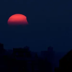 Una eclissi parziale del sole, mentre si tramonta, è vista da Shanghai Una eclissi parziale del sole, mentre si tramonta, è vista da Shanghai