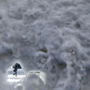 A person walks past a snow covered bus shelter in downtown Chicago