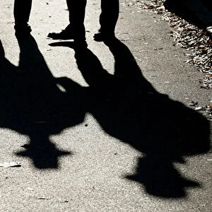 Police officers cast shadows while patrolling outside the U