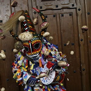 Revellers throw turnips at the Jarramplas, a character who wears a devil-like mask