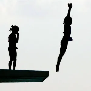 Schoolgirls dive from a five-metre platform at a swimming pool in Oiso