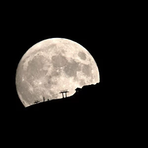 A ski lift at the Kalavrita ski centre on Mount Helmos is silhouetted as the moon rises