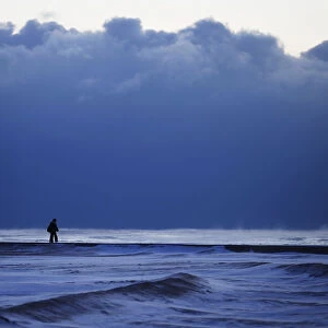 A woman walks along a frozen beach at Lake Michigan in Chicago
