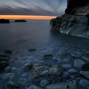Bay with pebbles on beach, on chalk headland at sunset, Thornwick Bay, Flamborough Head, North Yorkshire, England, may
