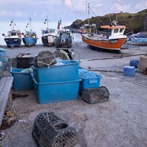 Fishing boats moored on shingle beach in evening sunlight, Cadgwith, Lizard Peninsula, Cornwall, England, August