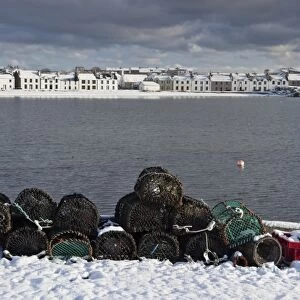 Lobster creels and snow covered seaside town, Port Ellen, Loch Leodamais, Isle of Islay, Inner Hebrides, Scotland