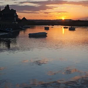 View of boats in coastal creek at high tide, silhouetted at sunset, Burnham Deepdale, Norfolk, England, march