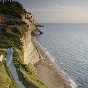 View of steps down to beach from steep cliffs in evening sunlight, Logas Beach, Peroulades, Corfu, Ionian Islands