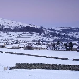 View of village and fells in heavy snowfall at dusk, Reeth, Swaledale, Yorkshire Dales N. P