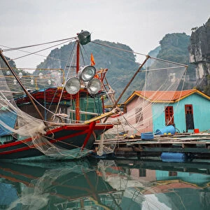 Asia, Vietnam, Quang Ninh, Ha Long Bay. Colorful fishing boat at its dock is reflected