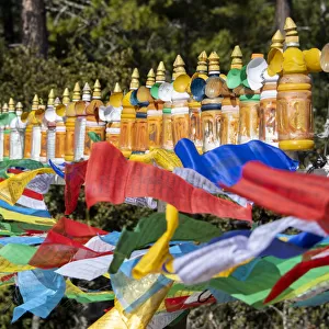 Bhutan, Paro. Colorful prayer wheels and flags along the hiking trail to the Tiger