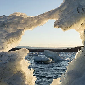 Canada, Nunavut, Territory, View of White Island through hole in melting iceberg