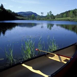 A canoe rests on the shore of Little Long Pond at Acadia National Park, Maine