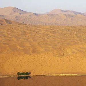 China, Inner Mongolia, Badan Jilin Desert. Desert vastness next to lake. Credit as