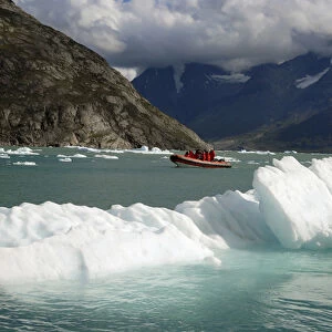 Greenland, Qooroq Fjord. A rubber raft navigates through a sea of icebergs on Qooroq