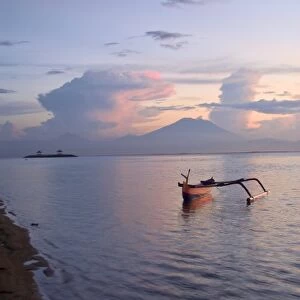 Indonesia, Bali. Sunrise on fishing boat and Sanur Beach with Mount Gunung Agung in distance