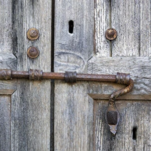 Italy, Tuscany. Unique metal door lock on an old wooden door