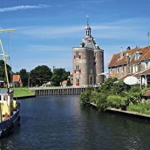 Netherlands, Enkhuizen, Classic Dutch vessels in the canal, Drommedaris Tower in the background