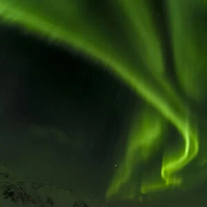 Northern Lights or aurora borealis near Hoefn, over the mountains of Vatnajoekull NP during Winter