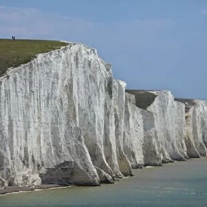 People atop Seven Sisters Chalk Cliffs, seen from Cuckmere Haven, near Seaford, East Sussex