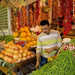Tangier Morocco Moroccan fruit & vegetable seller in stall at the covered market