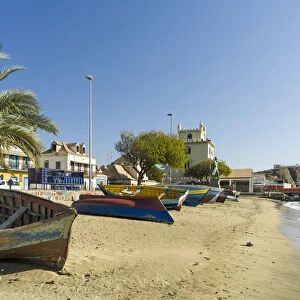 Traditional fishing boats on the beach of the harbor, landmark Torre de Belem in the