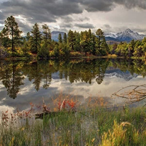 A tranquil pond reflects Mt. Snaffles and Fall in the Colorado Rocky Mountains