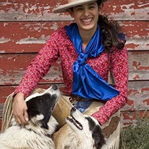 USA, Oregon, Seneca, Ponderosa Ranch. Portrait of a smiling cowgirl and her two dogs