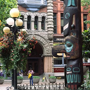 USA, Washington, Seattle. Tlingit totem pole, antique street lamps & historic Pioneer