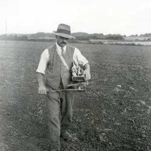 Farm worker fiddling trifolium [clover] seed, September 1933