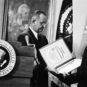 (1904-1967). American physicist. Oppenheimer is presented the Enrico Fermi Award by President Lyndon Johnson on 2 December 1963, for his contributions to theoretical physics the atomic energy program