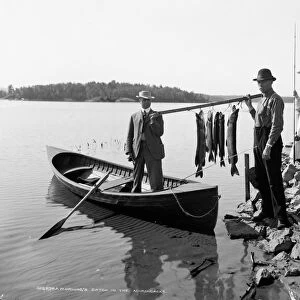 ADIRONDACKS: FISHING, c1903. Two fisherman with a days catch, in the Adirondacks, New York