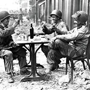 Three American soldiers at a sidewalk cafe in Paris, France, following the Allied liberation of the city, August 1944
