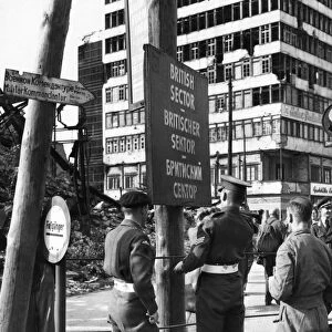 BERLIN, 1948. British military police erecting a sign to mark the division of British