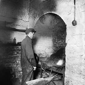 BLACKSMITH, c1920. A blacksmith standing at the kiln, Washington, D. C. Photograph