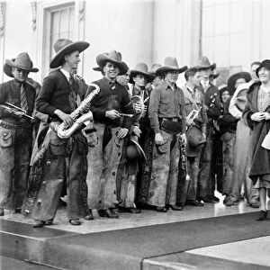 COWBOY BAND, 1929. Lou Hoover greeting a cowboy marching band from Simmons University in Abilene
