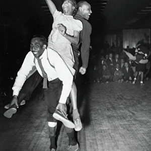 Three dancers dancing the Harlem conga, a blend of the lindy hop, conga and the Australian kangaroo hop, at a dance hall in Harlem, New York, 1941