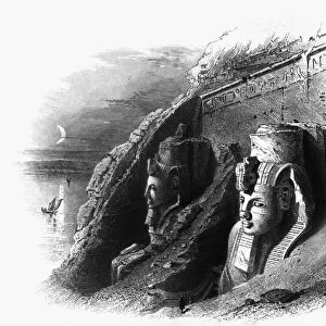 EGYPT: ABU SIMBEL. A view of the partially excavated colossal statues of Ramses II at the entrance to the great temple at Abu Simbel, Egypt, carved from rock in the 13th century B. C. Line engraving, English, 1849
