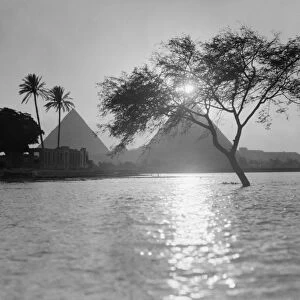 EGYPT: NILE, c1934. A view of the pyramids along the Nile River at sunset. Photograph