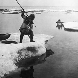 ESKIMO FISHERMEN. Two eskimo fishermen, one poised with a harpoon. Undated photograph